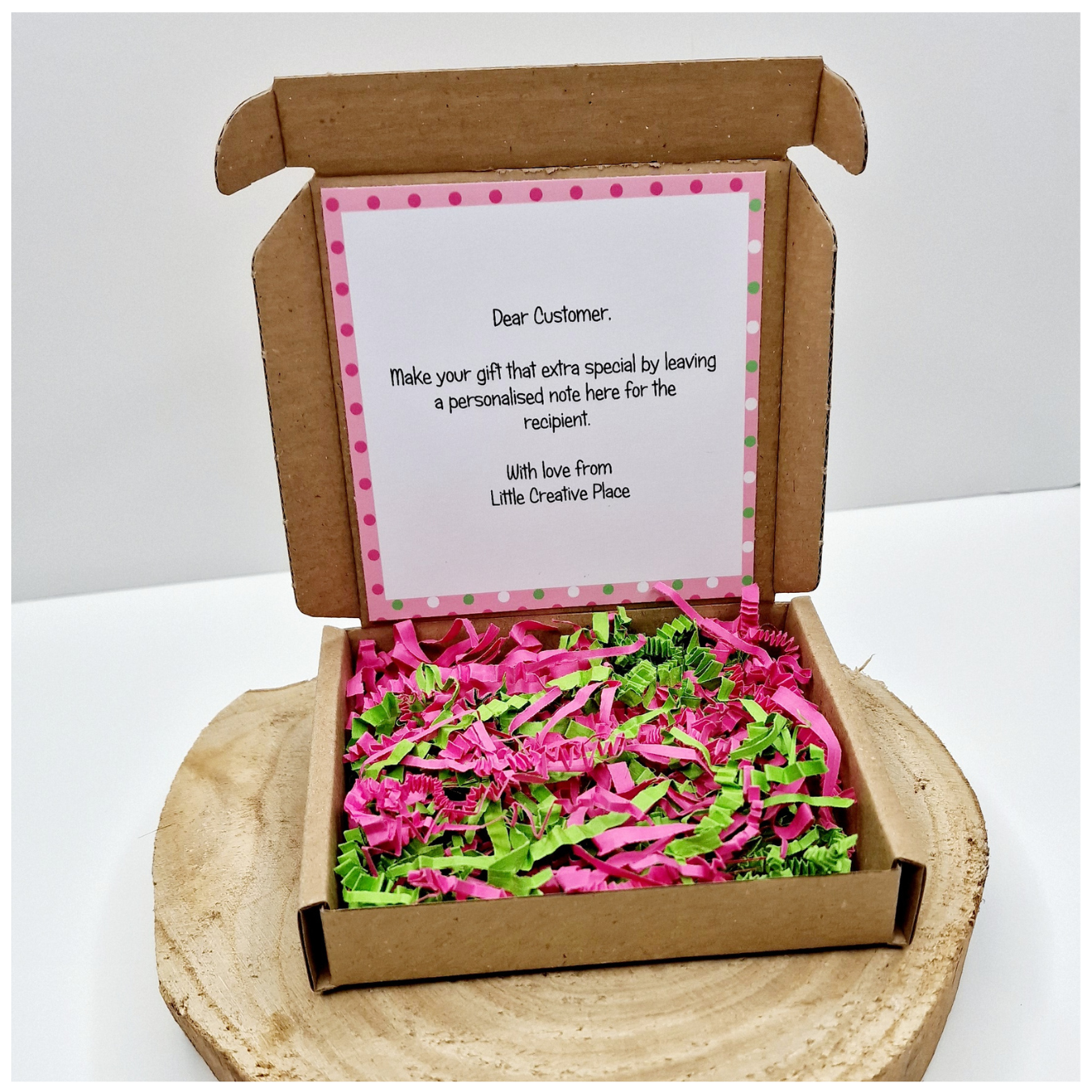Presentation gift box with personalised note card inside lid and pink and green shredded paper