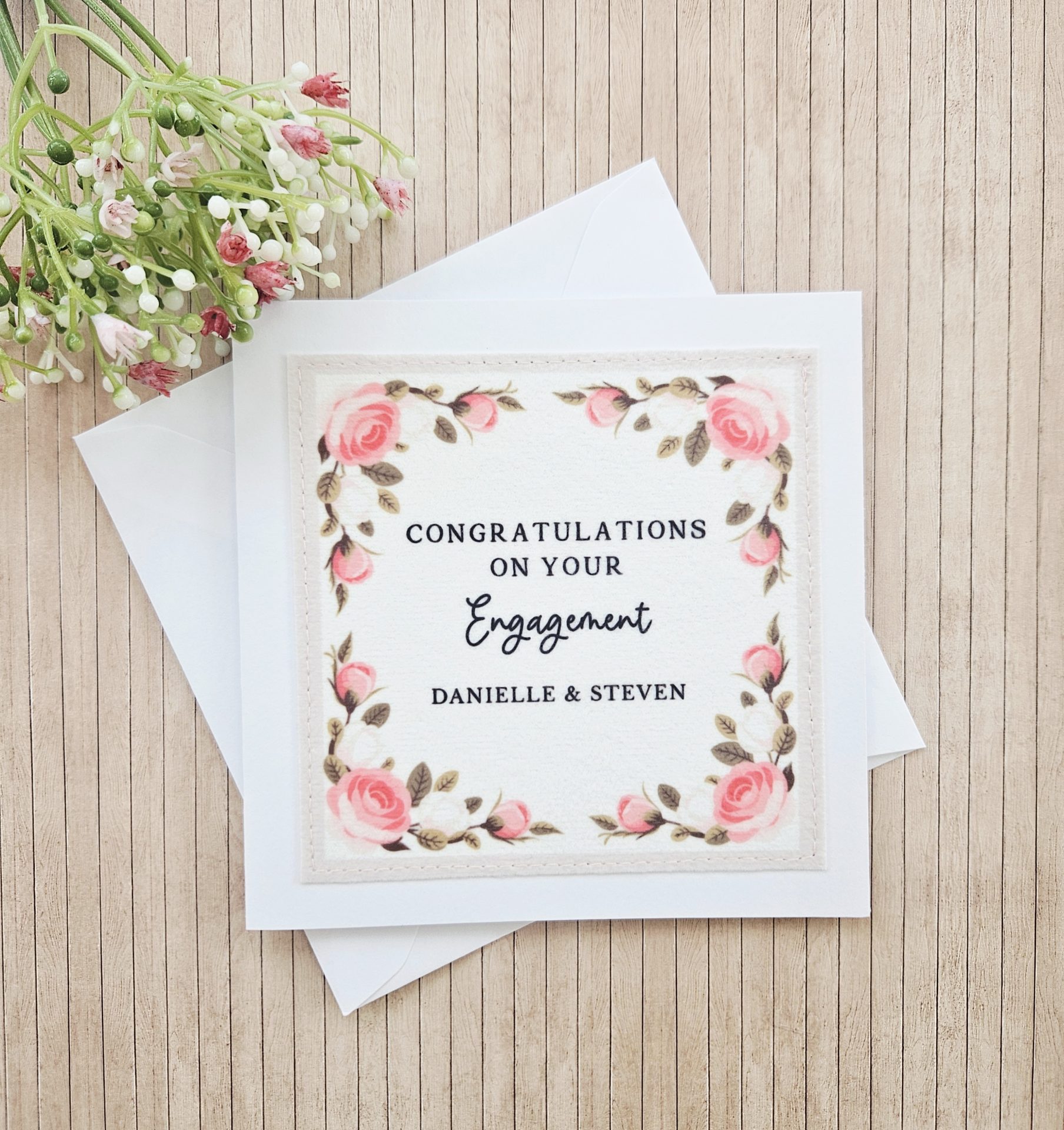Romantic floral engagement card styled with envelope and decorative flowers
