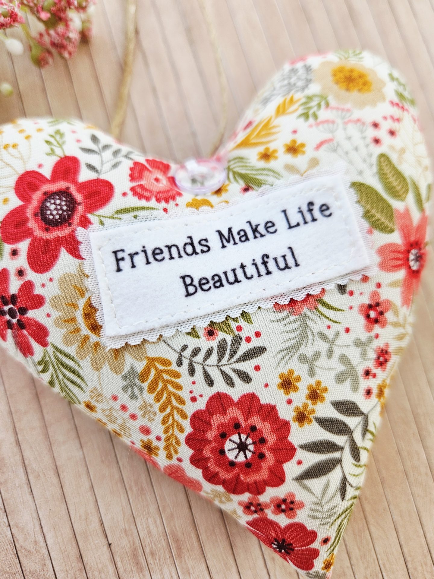 Close up friendship hanging heart gift stitched label detail