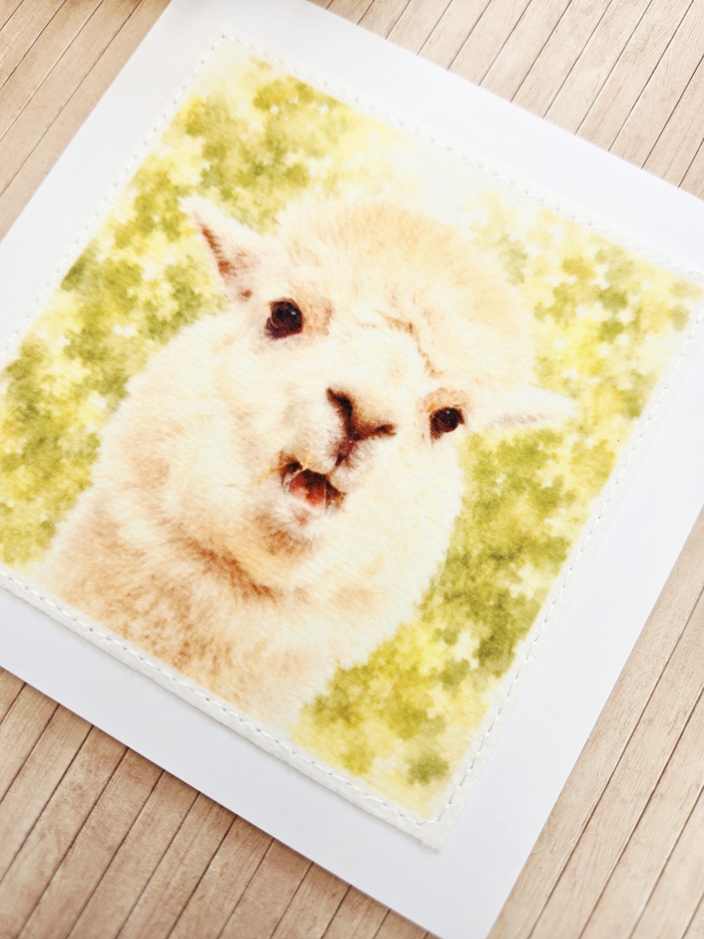 Detailed view of a handmade alpaca wildlife card and coordinating white paper envelope.