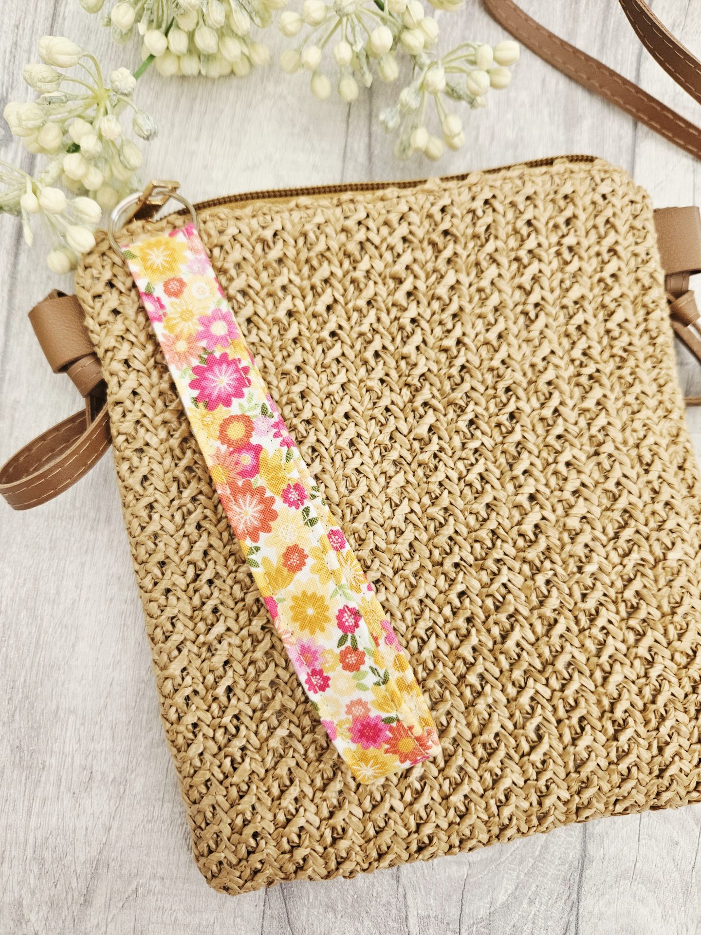 Floral fabric wristlet attached to a woven handbag for everyday use