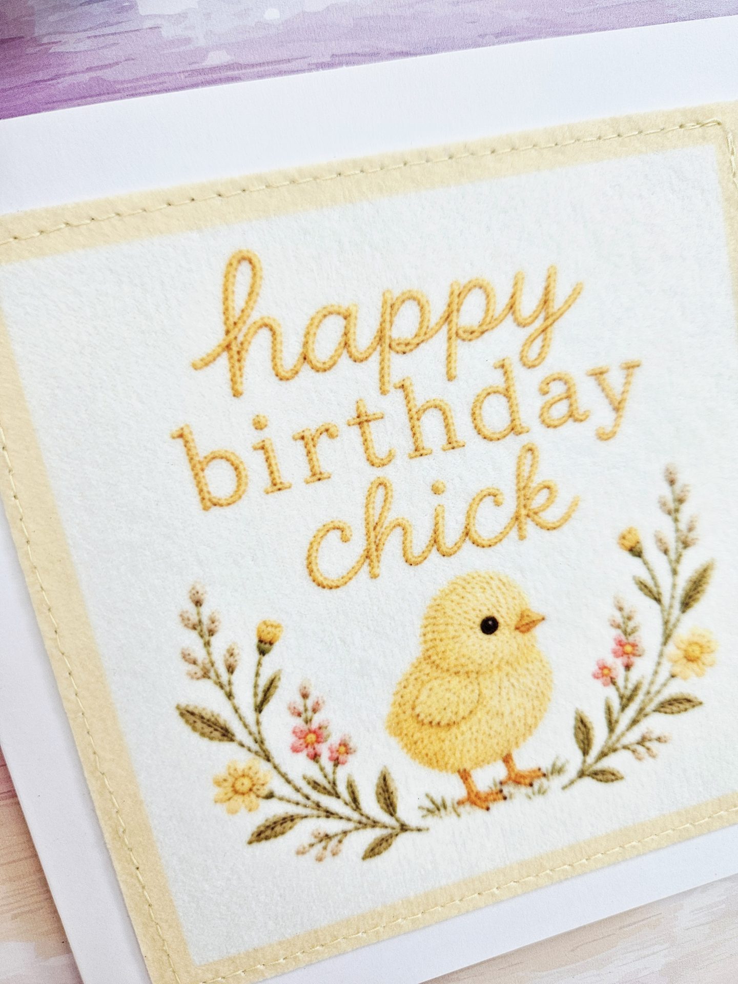 Close-up of the handmade birthday chick card focusing on the embroidered lettering and stitching details.