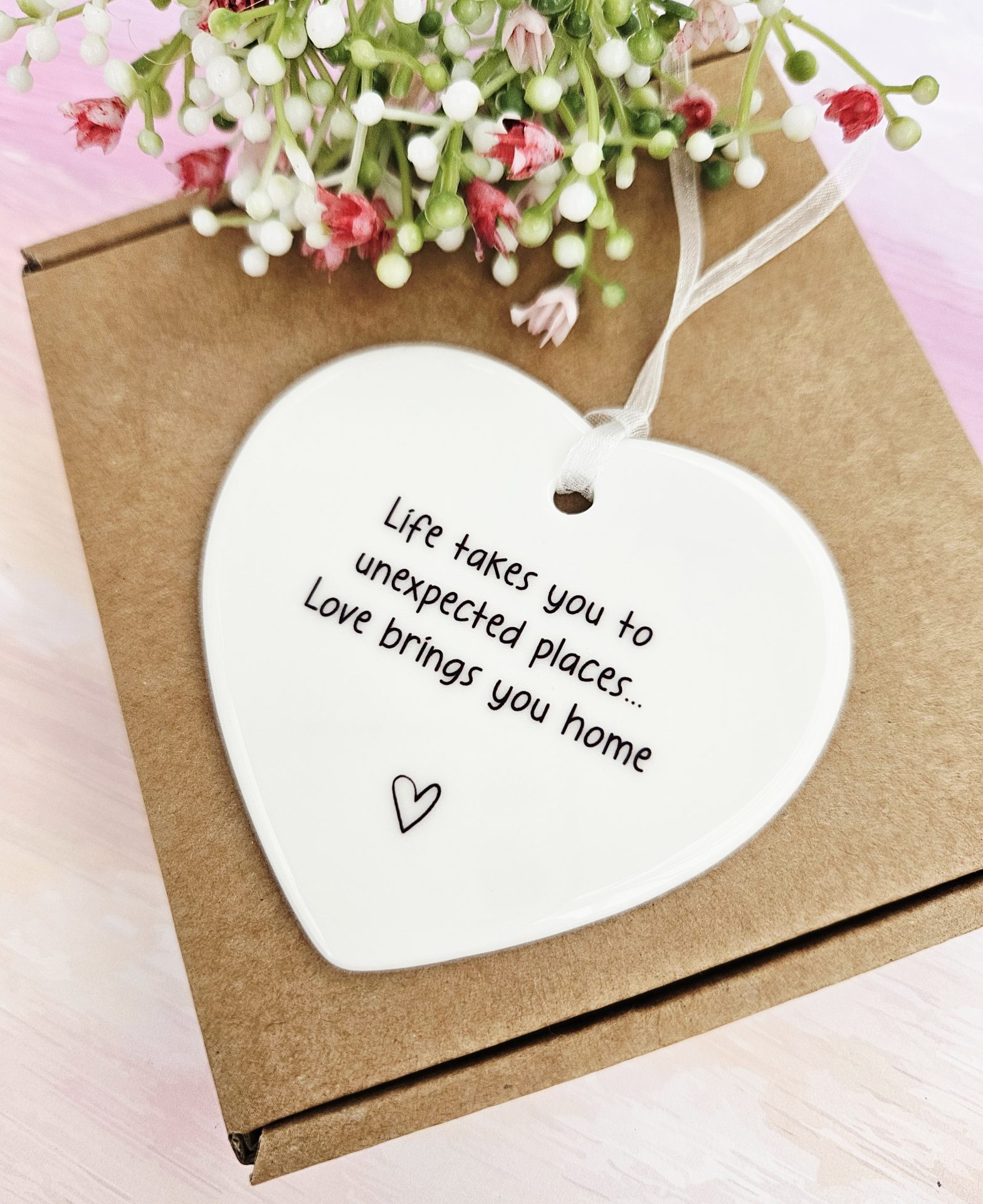 Life takes you to unexpected places ceramic heart displayed on a brown gift box