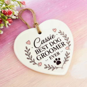 Close-up of a personalised dog groomer ceramic heart with custom name, Best Dog Groomer Ever design and glossy finish.