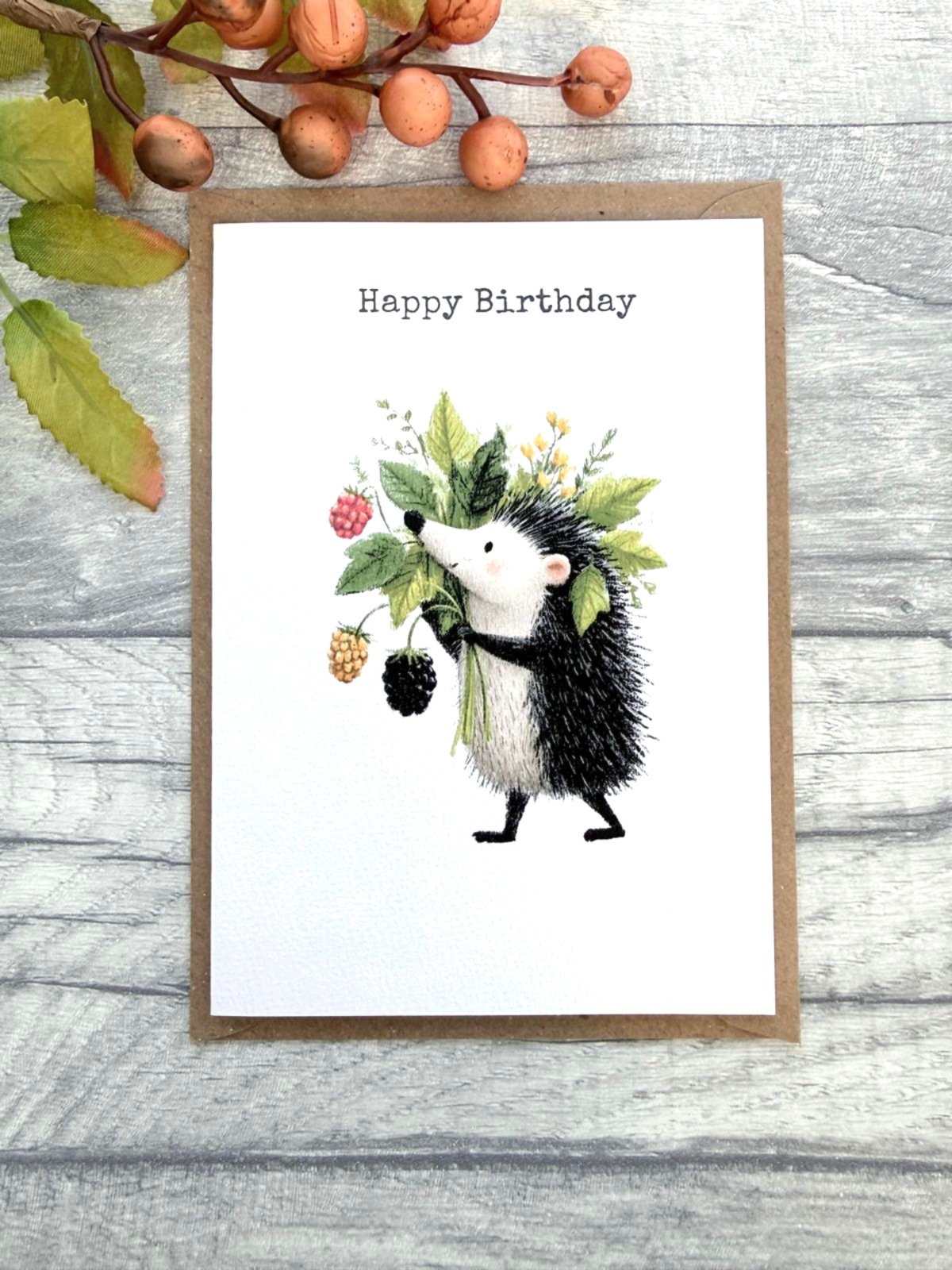 Woodland hedgehog birthday card with berries and leaves on textured white card