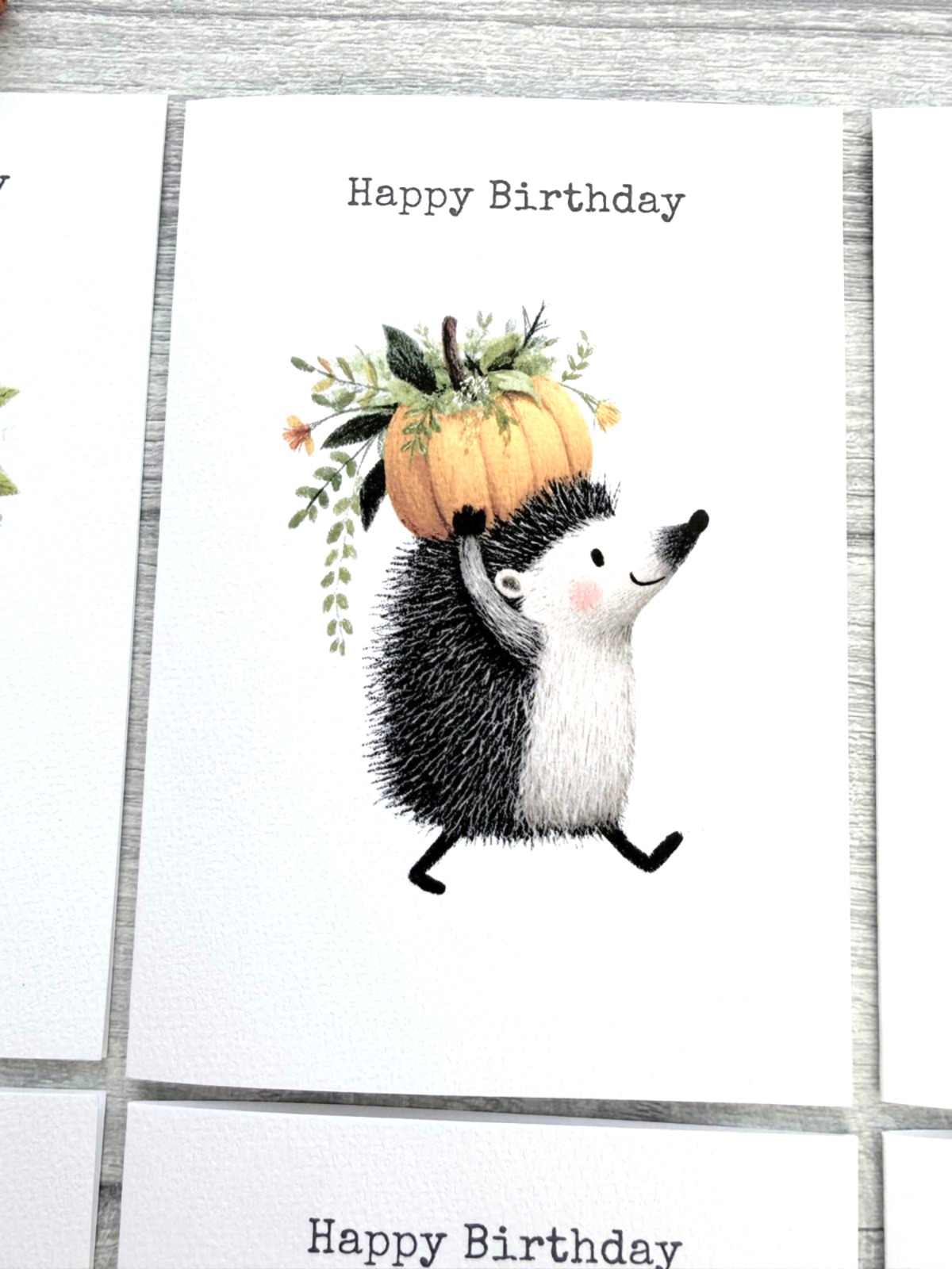 Whimsical hedgehog birthday card featuring a pumpkin and botanical woodland design